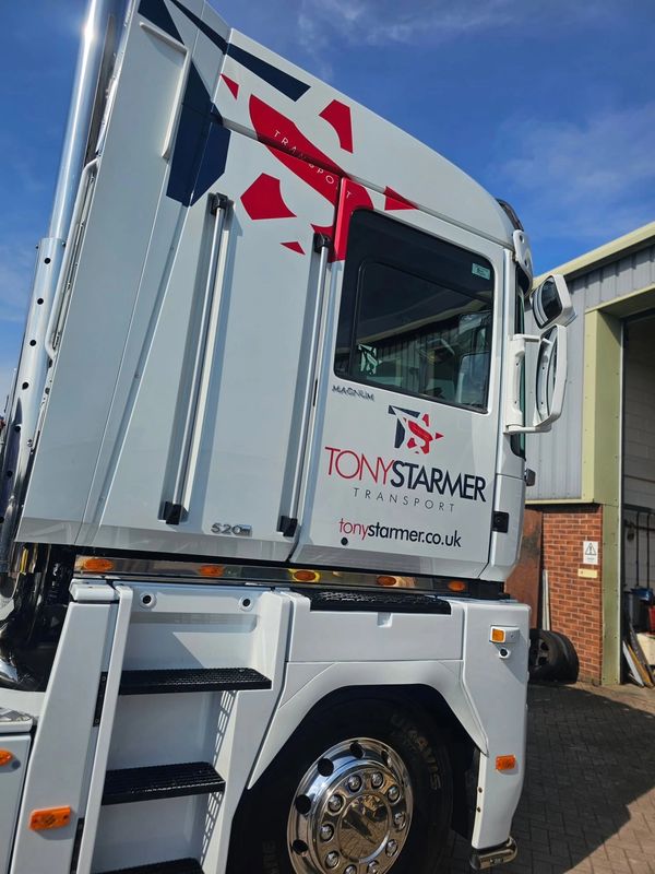 White Tony Starmer Transport truck under blue sky.