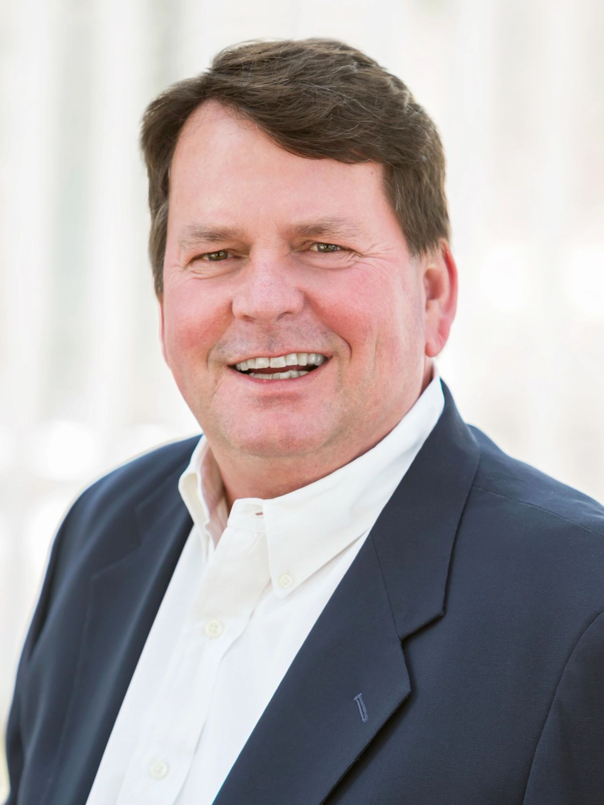 Close-up of a smiling man in a suit.