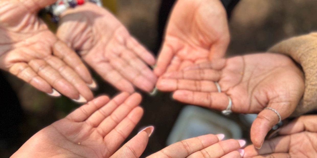Several open hands gathered together in a circle.