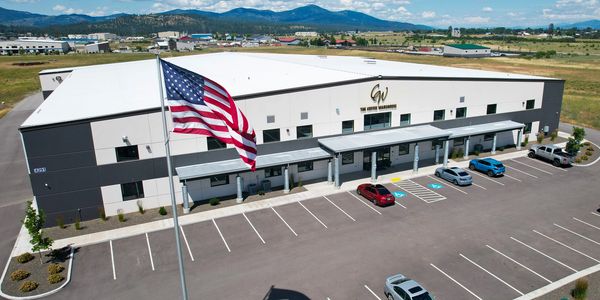 The Coffee Warehouse building with cars and an American flag.