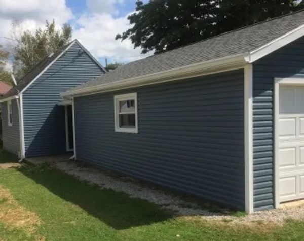 Thompson and Son's installing new siding and reframing of garage.
