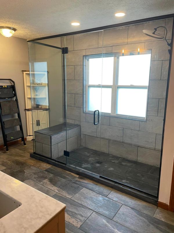 Thompson & Son's installed and finished custom tile with added bench seat and custom glass surround.