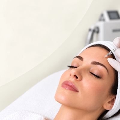 Woman receiving cosmetic injection on forehead.