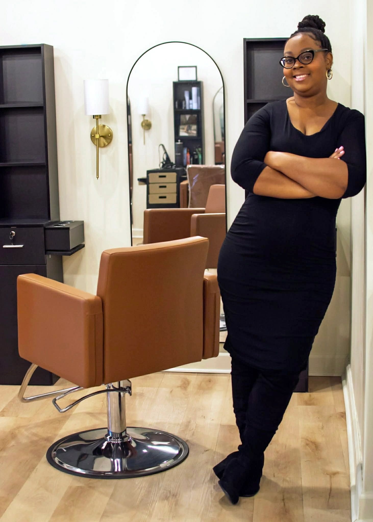 Woman with glasses standing in a stylish salon.