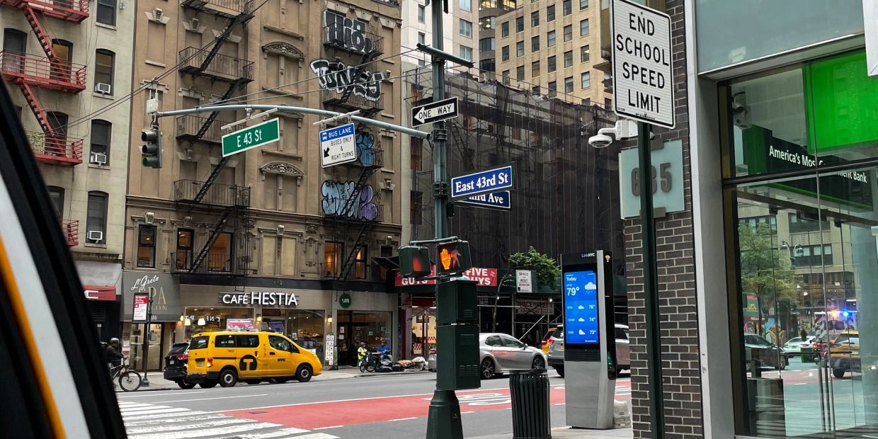 Street view of E 43rd St with traffic and buildings.