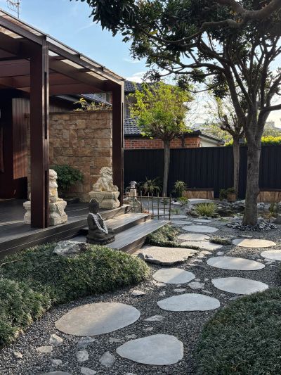 Serene garden pathway with stone steps and greenery.