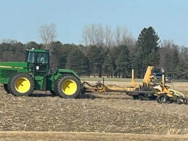 Tractor pulling injection tool bar attached to a dragline system for liquid manure application.