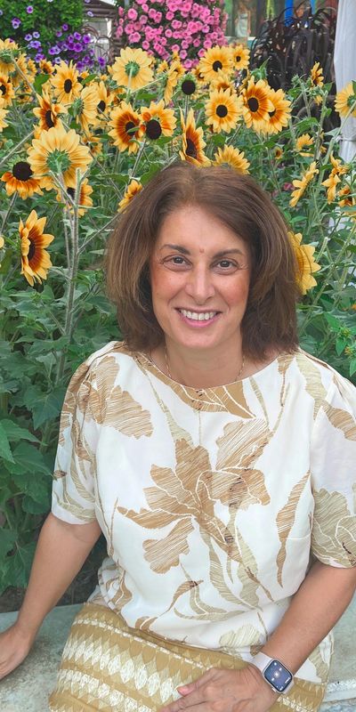 Filomena Lo Conte is smiling surrounded with sunflowers. 