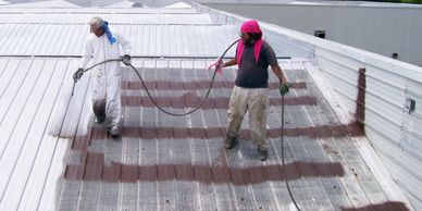 Asphalt based aluminum roof coating being applied in order to restore steel finish and stop rust.