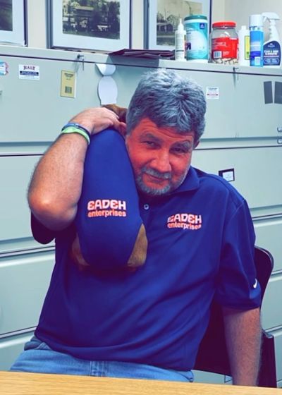 Man in blue shirt stretching his shoulder.