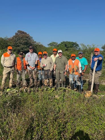 Group of hunters posing with their game birds on a sunny day.