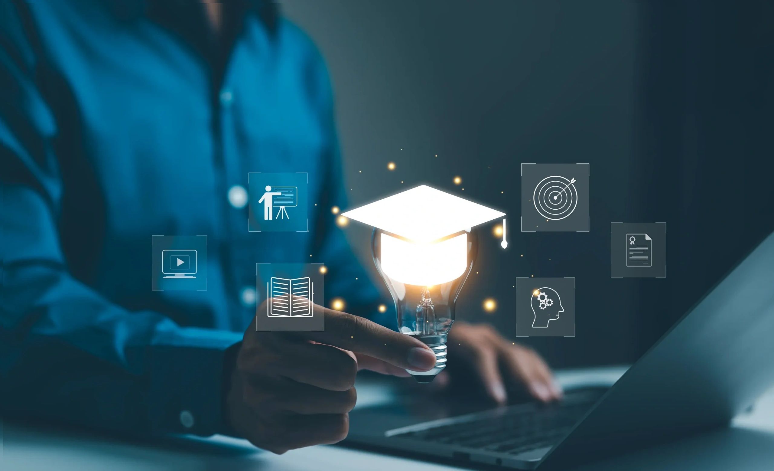 Hand holding glowing lightbulb with graduation cap and education icons around it.