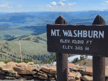 Signboard at Mt. Washburn showing elevation with scenic mountainous background at Yellowstone.