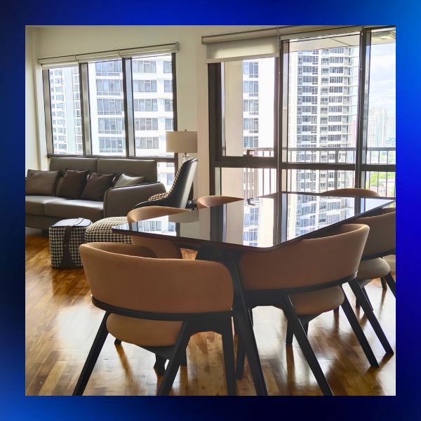 Modern dining area with chairs and a living room with large windows.