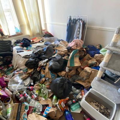 Badly hoarded and neglected living room with trash everywhere