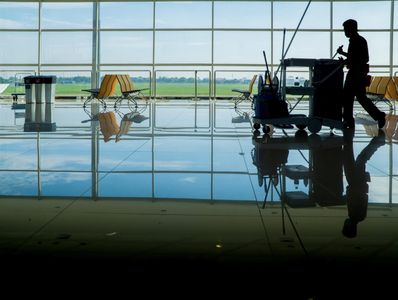 Persons silhouette walking with cleaning materials in commercial space