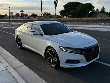 White sedan parked on a suburban street at dusk.