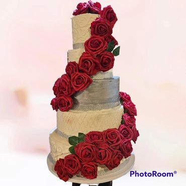 5 Tier Wedding Cake. All white with a silver middle tier. Red Roses wrapped around the cake.