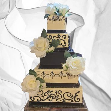 5 Tier Wedding Cake. White with black accents with the middle tier solid black. White flowers around.
