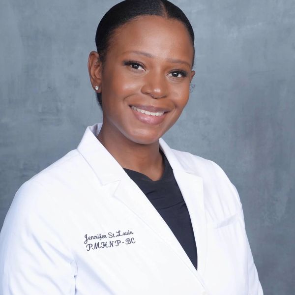 Professional woman in a white coat smiling.