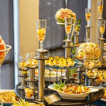 Elegant buffet setup with carved fruit decorations and assorted appetizers.