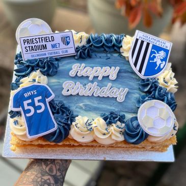 Birthday cake decorated with football theme and club logos.