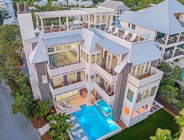 Modern multi-story house with balconies and swimming pool.
