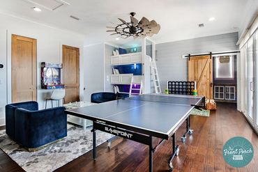 Modern game room with ping pong table and cozy seating area.