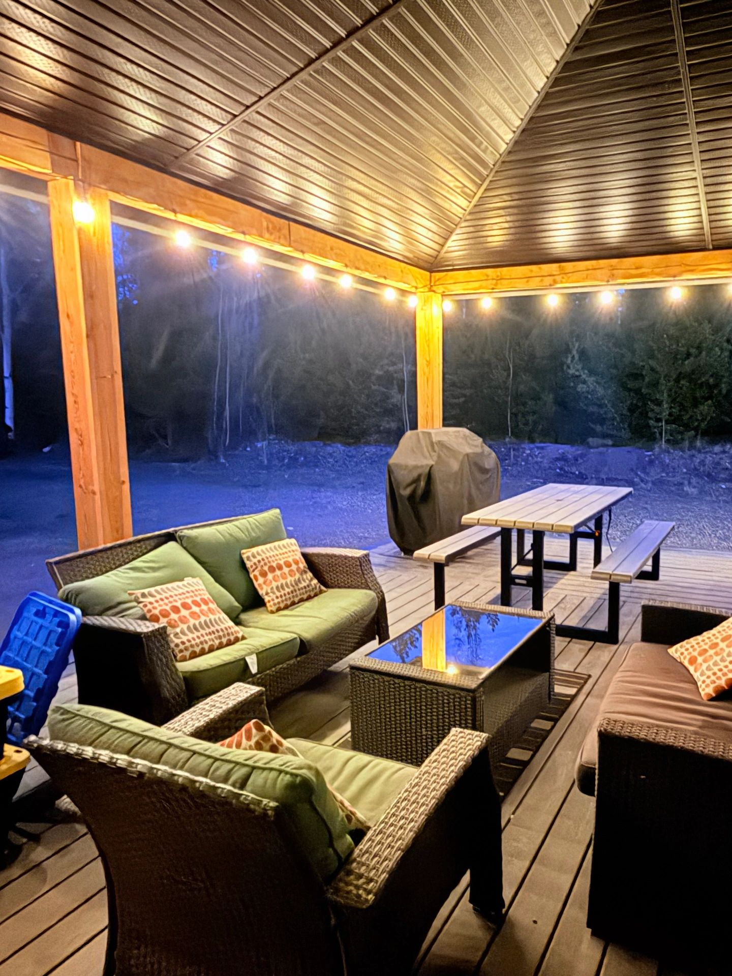 Cozy outdoor patio at dusk with string lights.