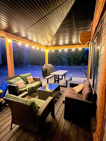 Cozy outdoor pavilion with seating and lights.