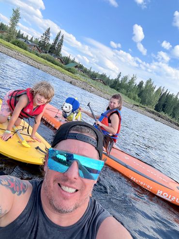 Two guests wearing sunglasses taking a selfie while kayaking on McCulloch Lake.