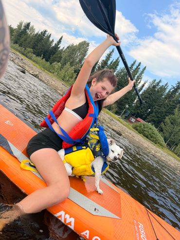 Guest kayaking on McCulloch Lake, paddling with arm raised on a sunny day.