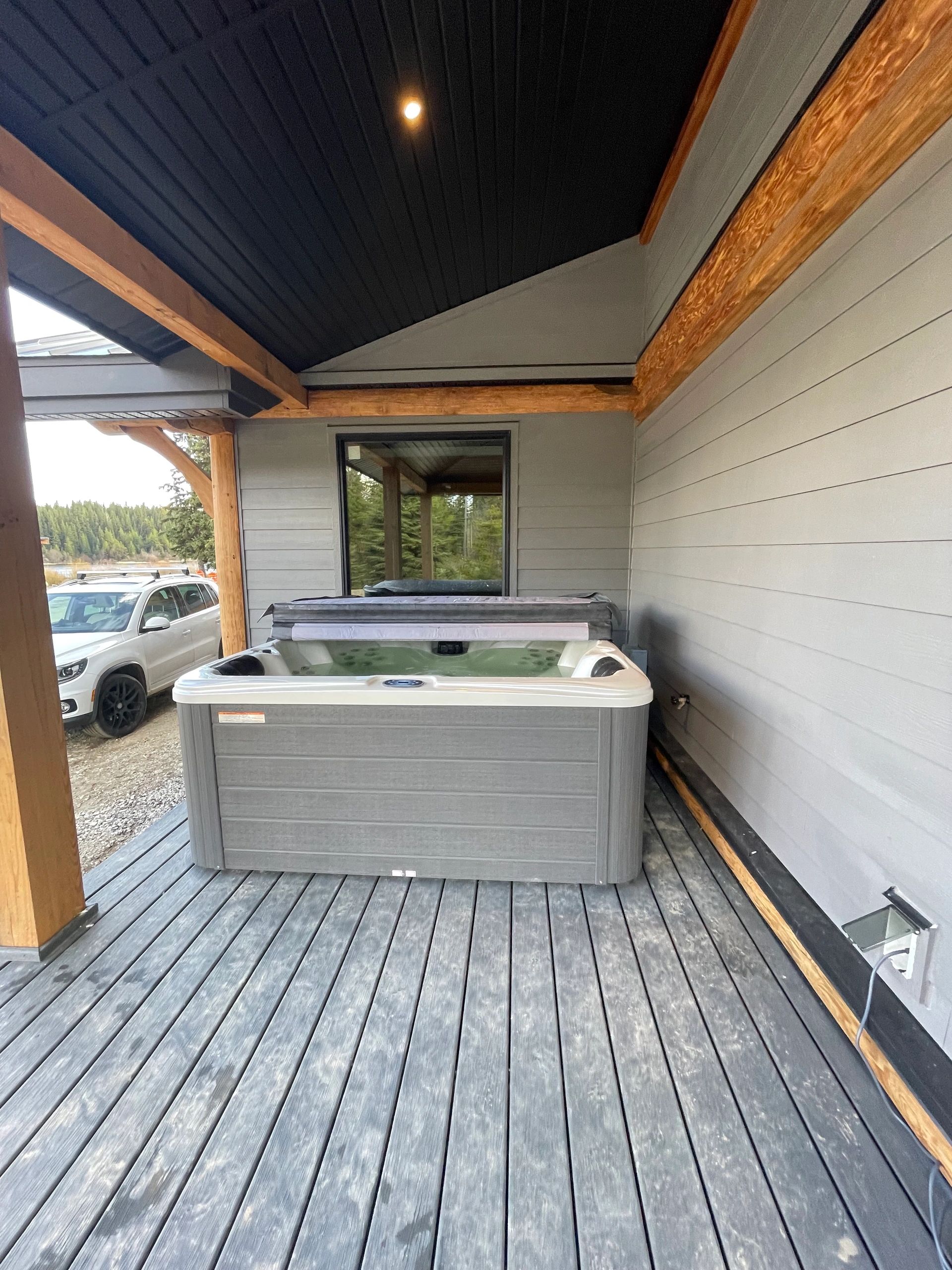Private hot tub on the covered deck at McCulloch Lake Cabins, a Kelowna vacation rental.