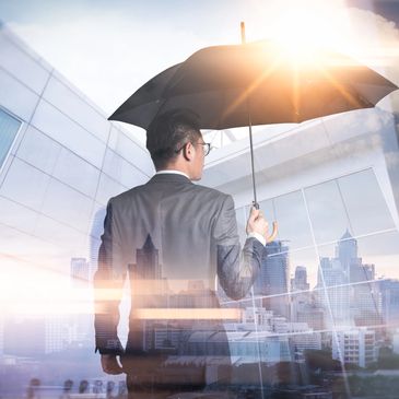 Man in suit with umbrella in a city.
