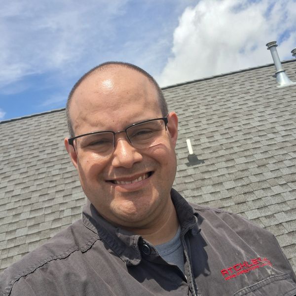 Home Inspector Ashlin Atchley smiling while inspecting a roof in Winchester, TN near Tims Ford Lake.