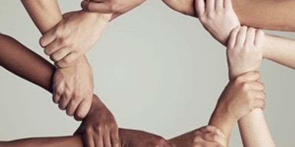 10 hands, each reflecting a different ethnicity, grasping the wrist next to it, forming a circle.