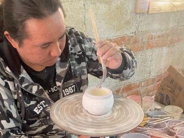 One of our extremely talented artisans in the middle of creating a colorful talavera mug