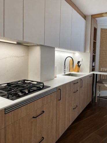 Cocina moderna con grifo negro y estufa empotrada.