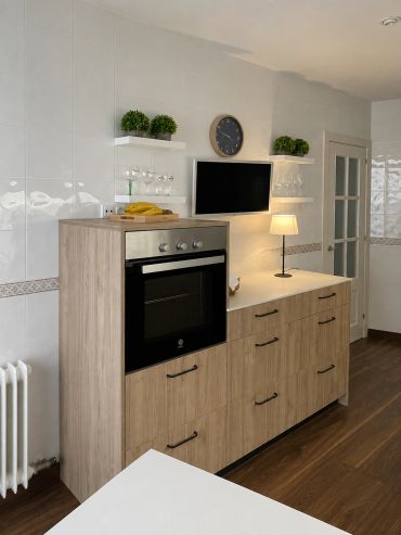 Cocina moderna con horno empotrado y decoración minimalista.