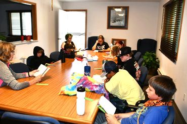 A group of campers and staff read a novel during 2 week reading.