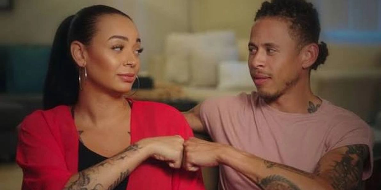 Couple fist bumping and looking at each other.