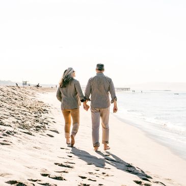 A retired couple walking on a beach