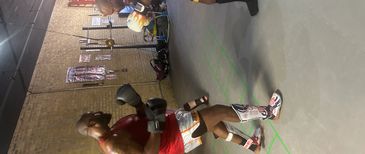 Two men sparring in a gym, one wearing red and the other in black and yellow.