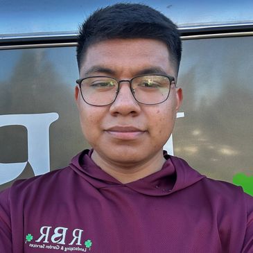 Young man wearing glasses and a maroon hoodie with logo.