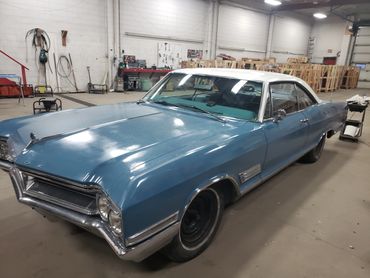 Classic blue and white Buick car in a spacious garage.