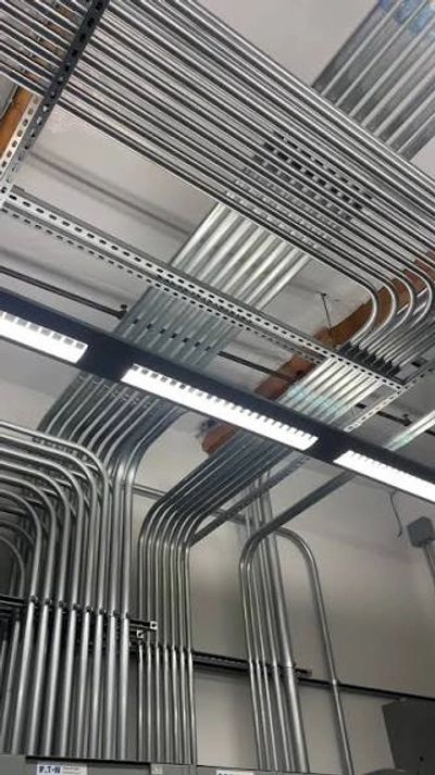 Neatly organized metal conduits on a ceiling.