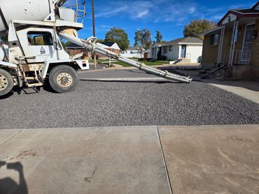 Concrete mixer truck pouring gravel for driveway construction.