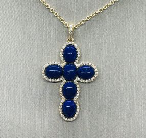 A cross pendant with 6 oval lapis lazuli framed in diamonds with a diamond bale on an 18 inch chain