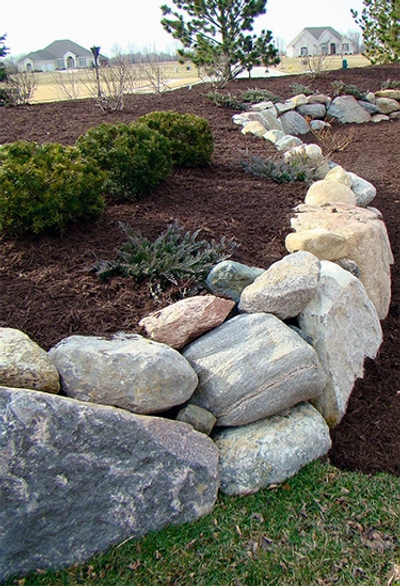 A boulder wall in a backyard