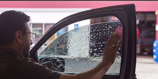 Installer applying window tint film to a window.